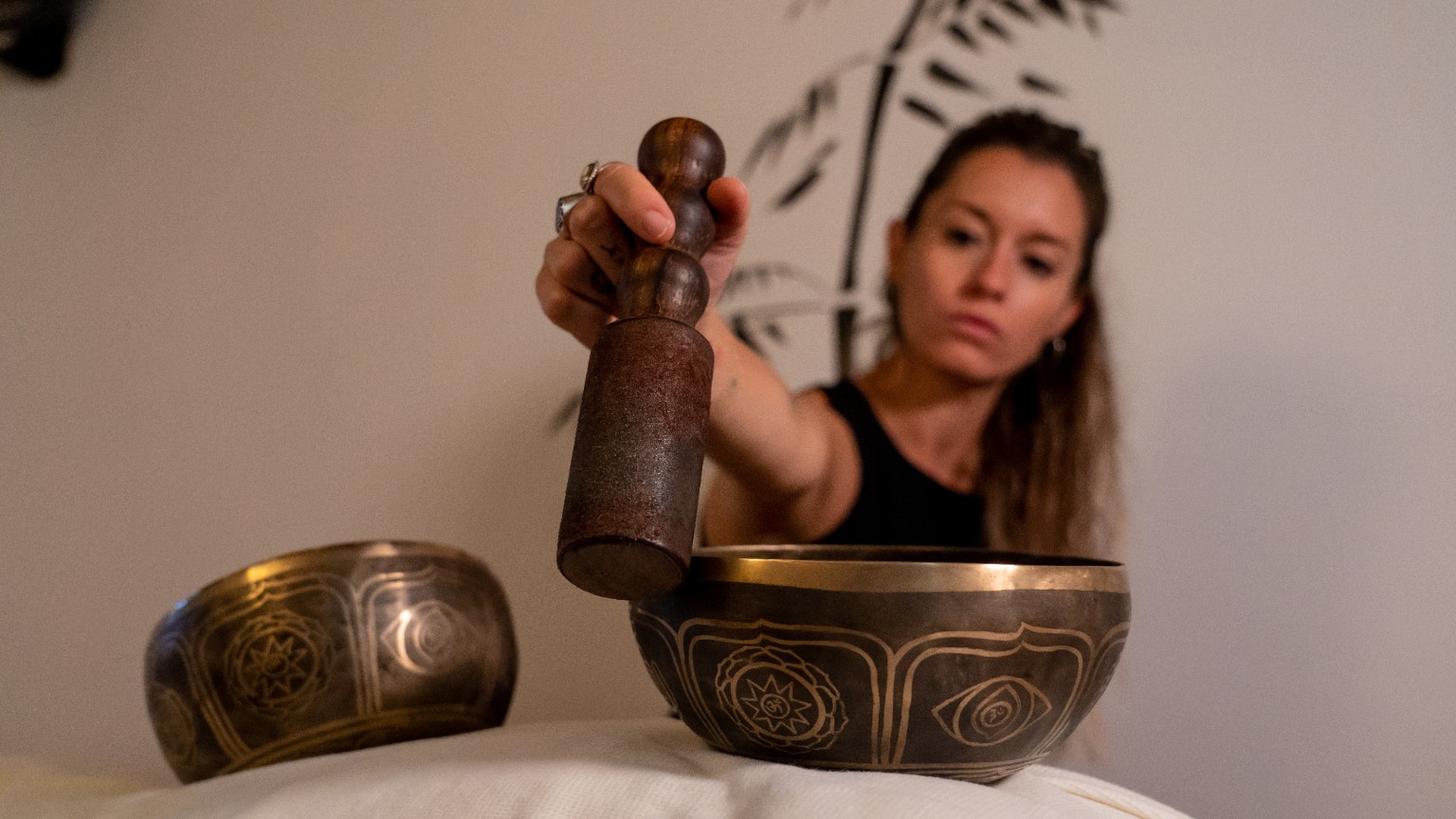 Terapeuta realizando una sesión de cuencos tibetanos en Zen